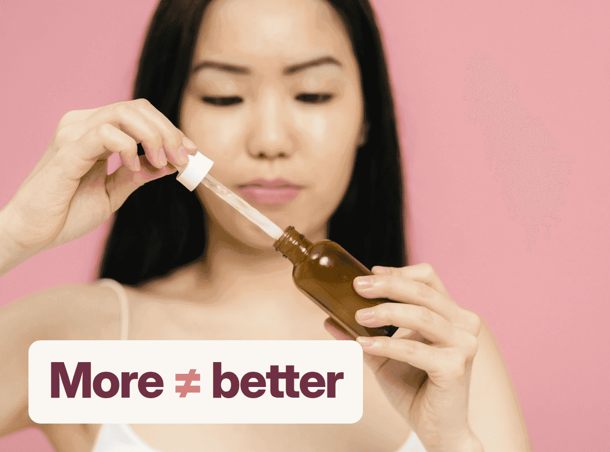 A woman filling a dropper from an amber serum bottle, with the words "More ≠ better".